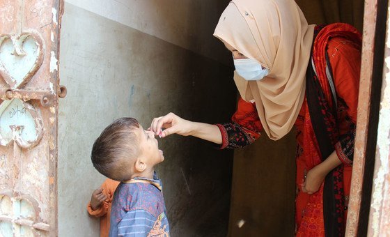 联合国儿童基金会的休斯纳·古尔给巴基斯坦的一名小男孩注射了口服脊髓灰质炎疫苗。